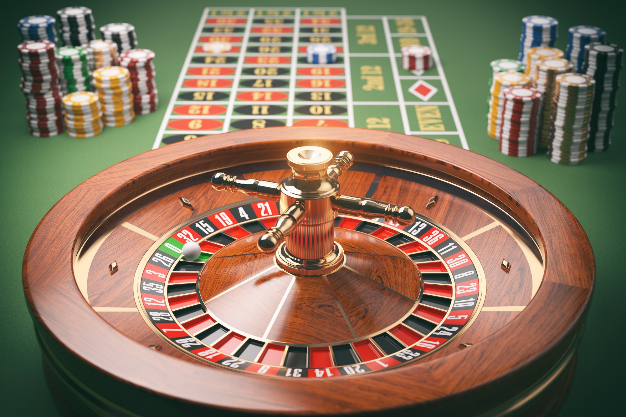 Casino roulette wheel with casino chips on green table. Gambling